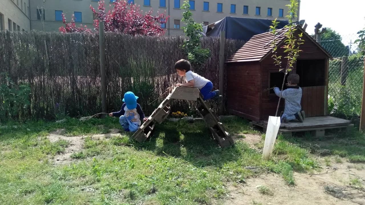 El jardí de Brolls, amb una caseta de fusta i infants jugant-hi